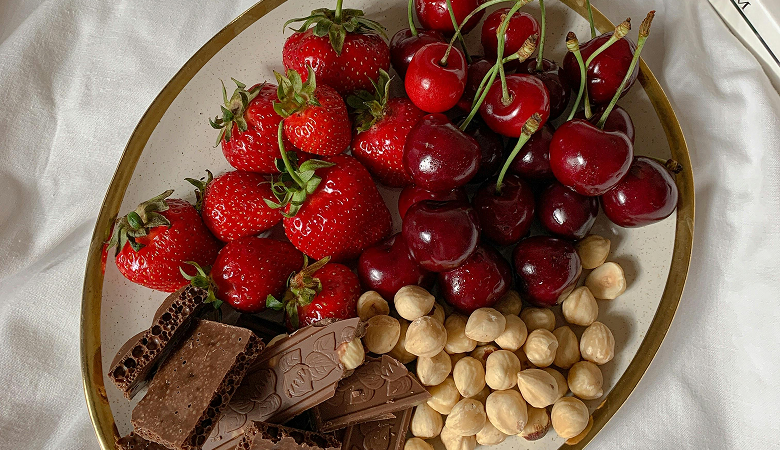 Strawberries, cherries, chocolate and hazelnuts on a plate